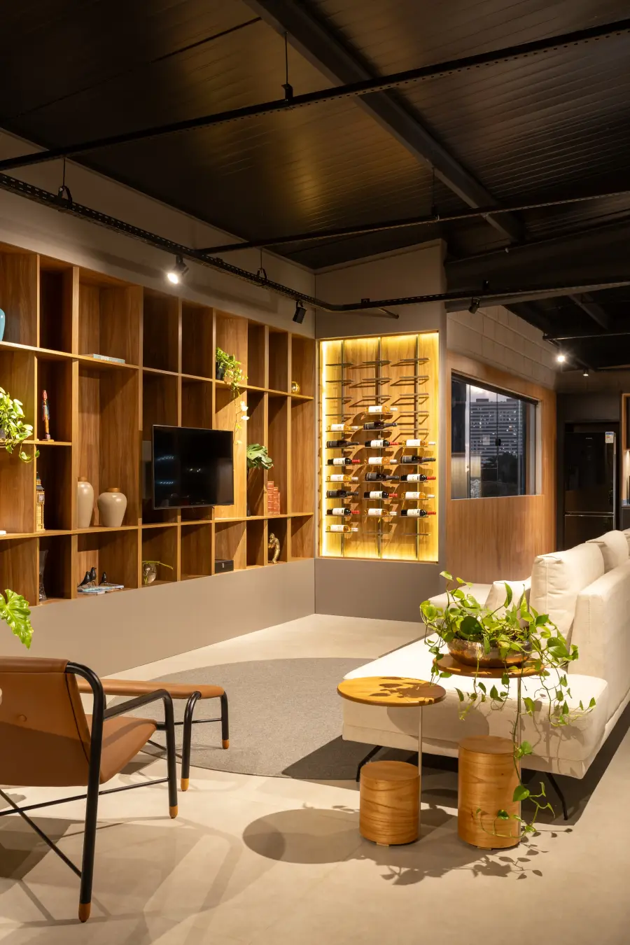 Sala de estar corporativa com estantes e decoração planejada.