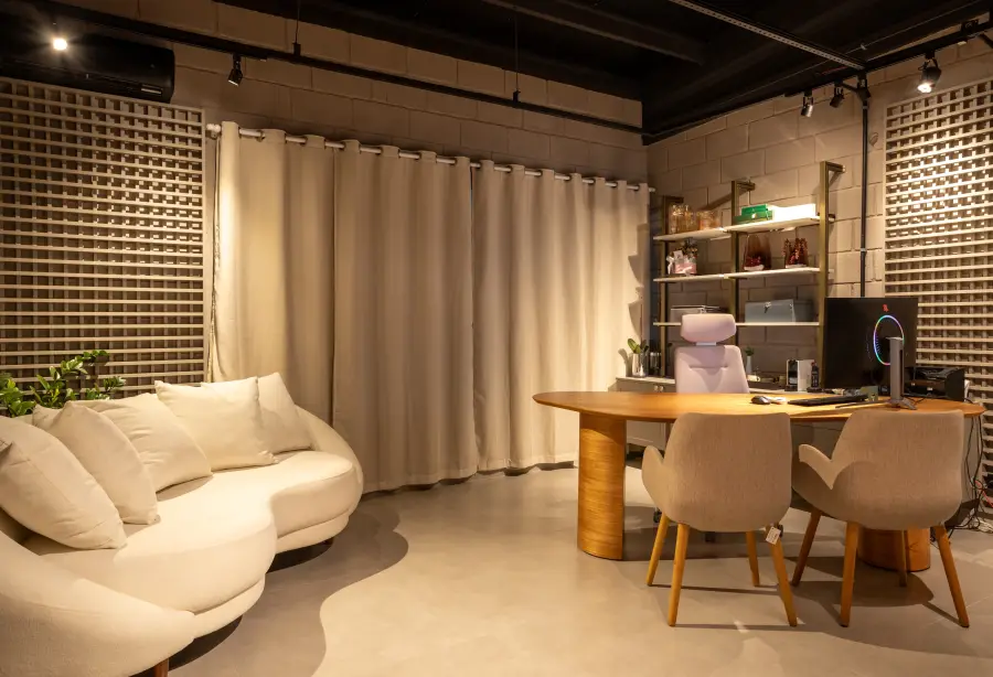Ambiente de reunião com cortinas e mesa de apoio.