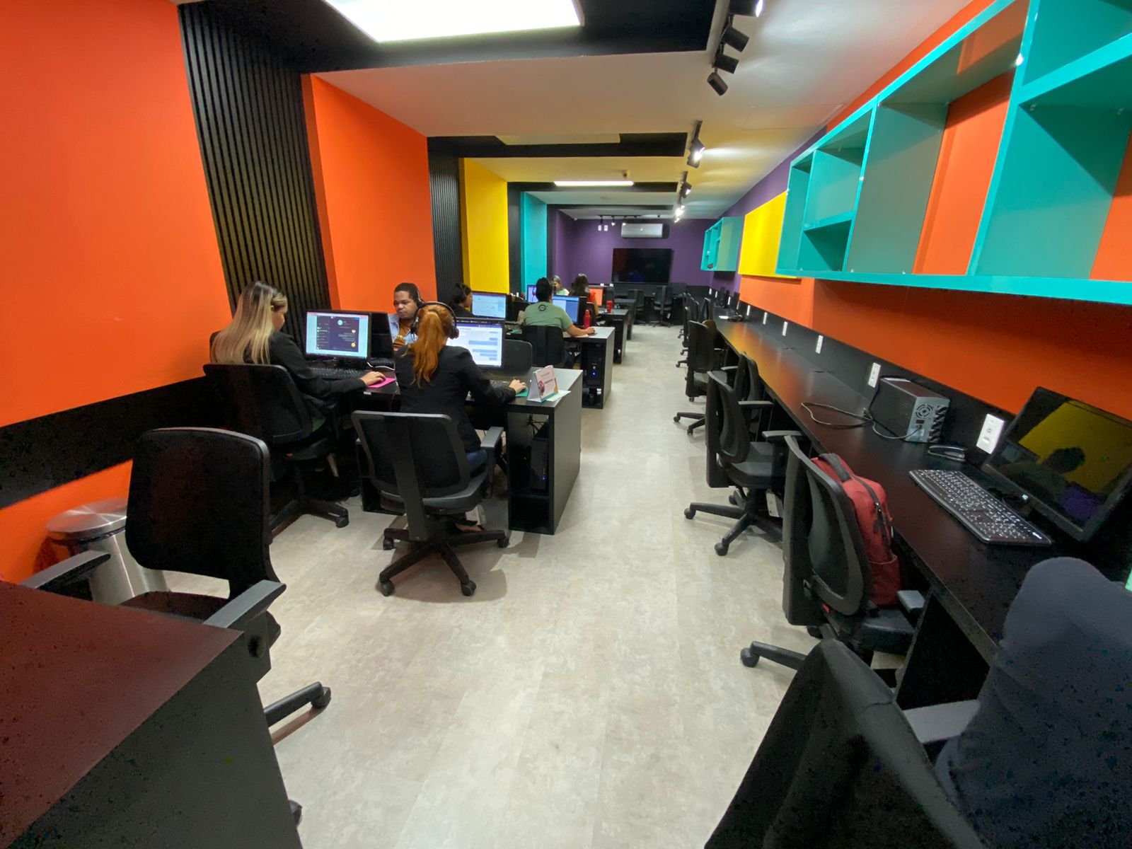 Recepção corporativa com poltronas claras, bancada central e copa em tons neutros.